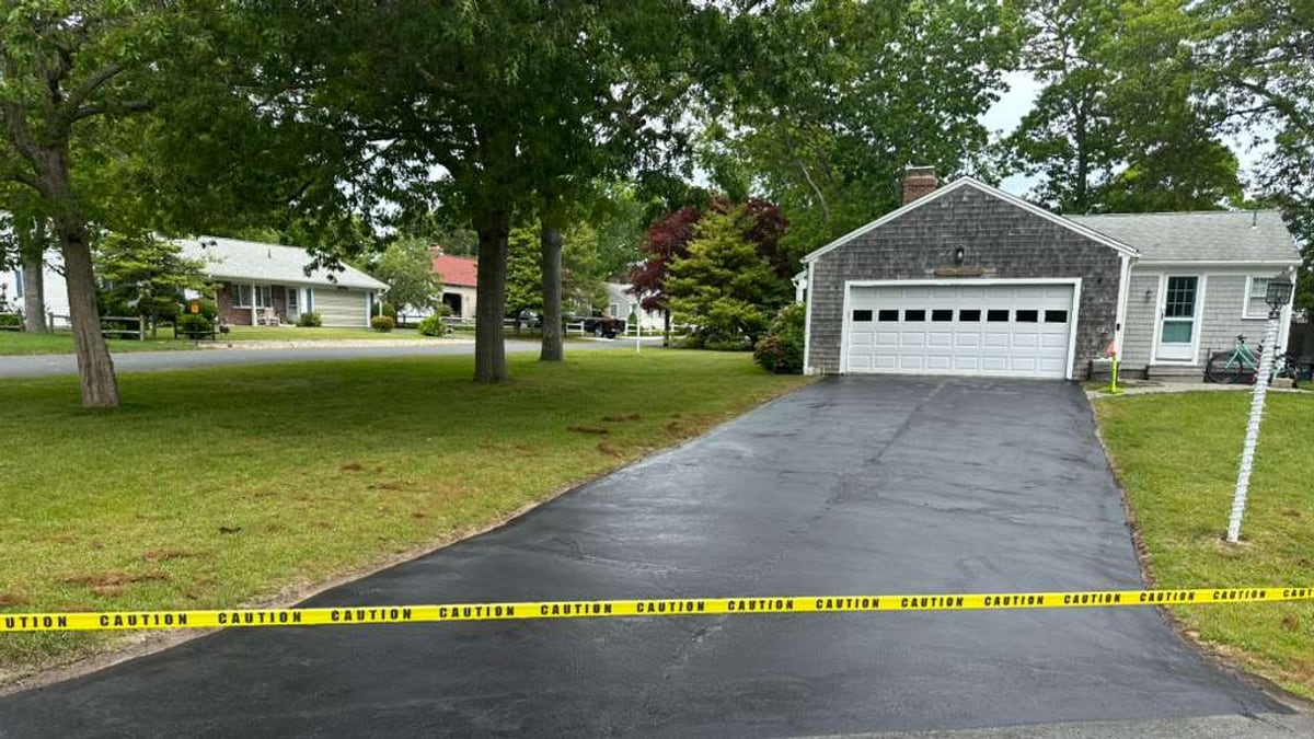 Same residential driveway after sealcoating with caution tape across the entrance